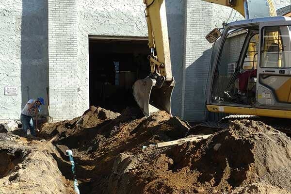 A backhoe, excavating dirt