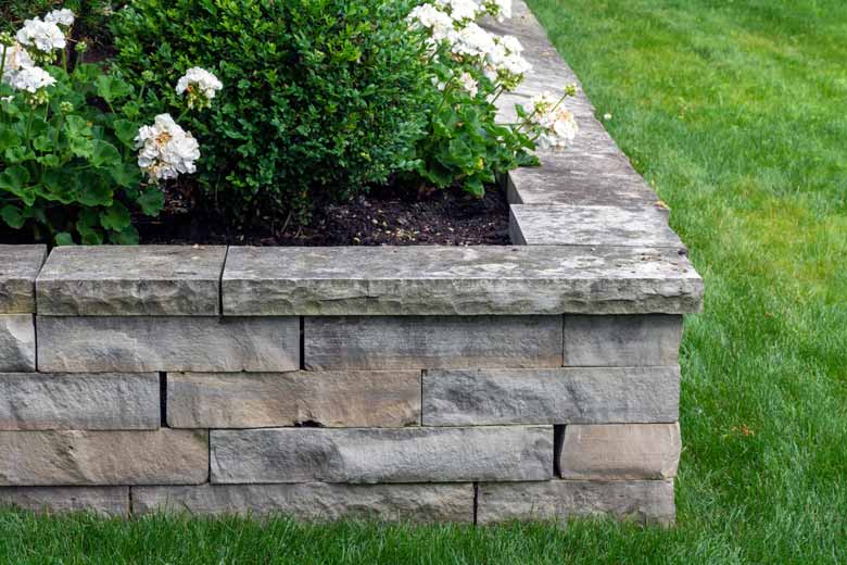 A raised flowerbed, made of stone blocks