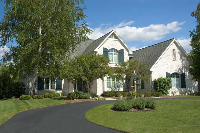 A white house with a new asphalt driveway